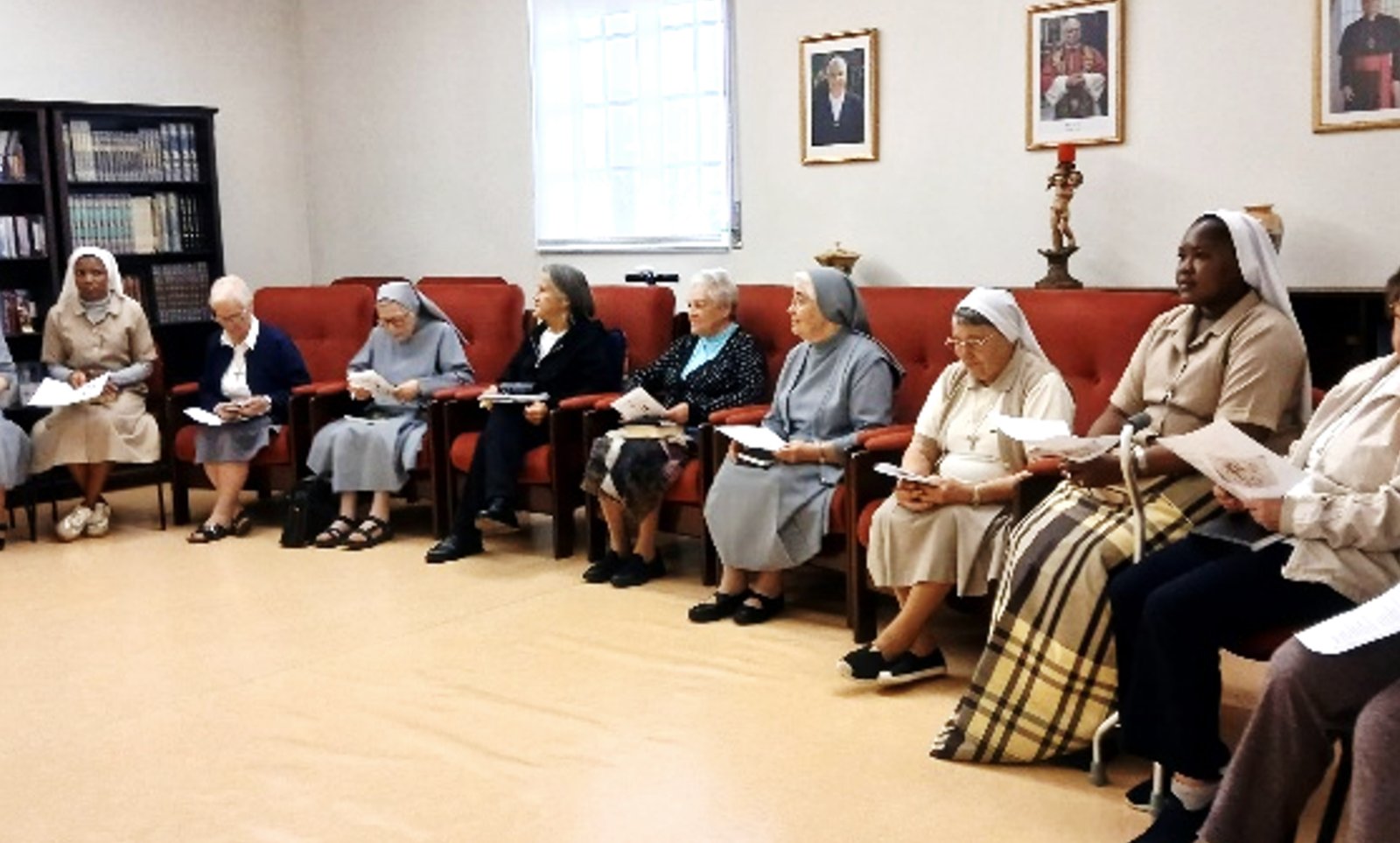 Religiosas de várias congregações sentadas em círculo numa sala, durante o retiro mensal.